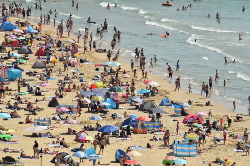 Beachgoers enjoy the sunshine as they sunbathe and play in the sea on Bournemouth beach in Bournemouth, southern England on July 31, 2020 as temperatures soar across the country. u00e2u20acu2022 AFP pic
