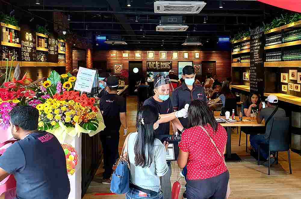 Staff taking the temperature of customers visiting the newly-opened Uncle Don's in Seremban. — Picture courtesy of Ian Ong