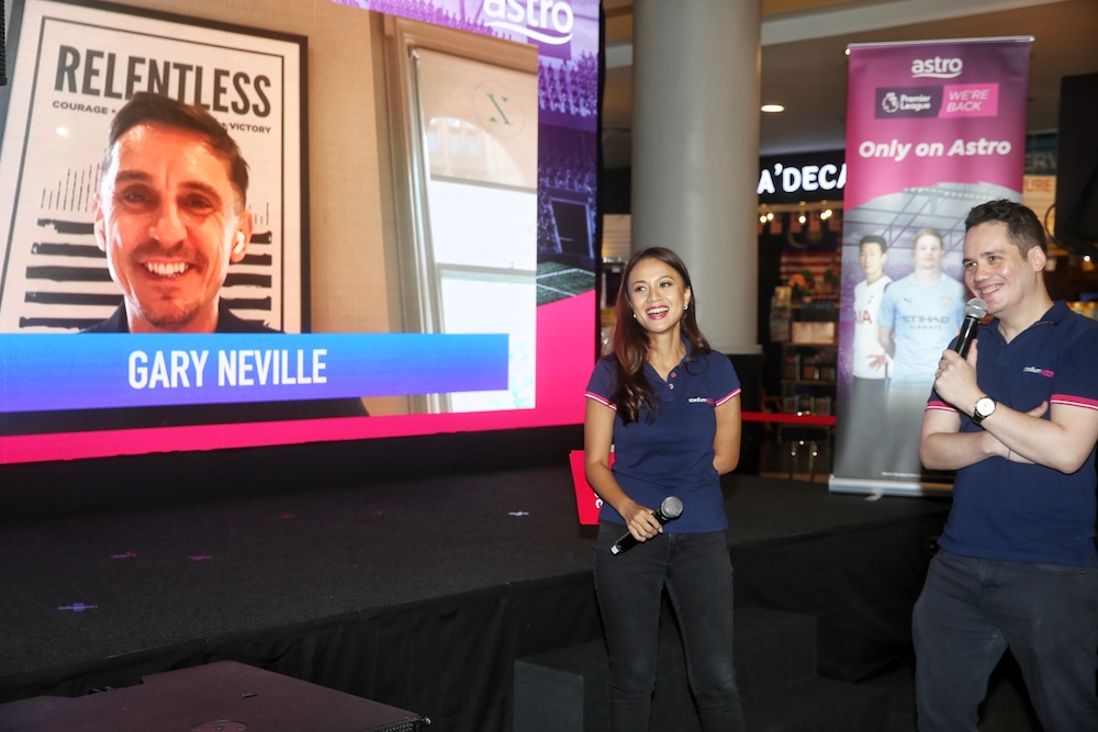 Astro SuperSport presenters Reem Shahwa and Adam Carruthers speaking to former Manchester United captain Gary Neville at the EPL event yesterday. — Picture by Choo Choy May