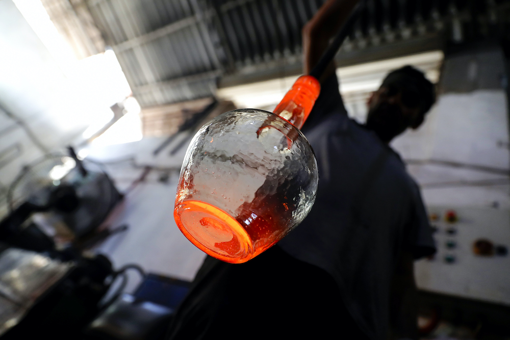 A glassblower forms glass at factory, which is recycling the broken glass as a result of the Beirut explosion, in the northern Lebanese port city of Tripoli on August 25, 2020. u00e2u20acu201d AFP pic
