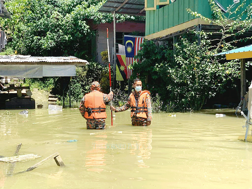 Firefighters check the water level at a village in Song. u00e2u20acu201d PIcture via Borneo Post Online