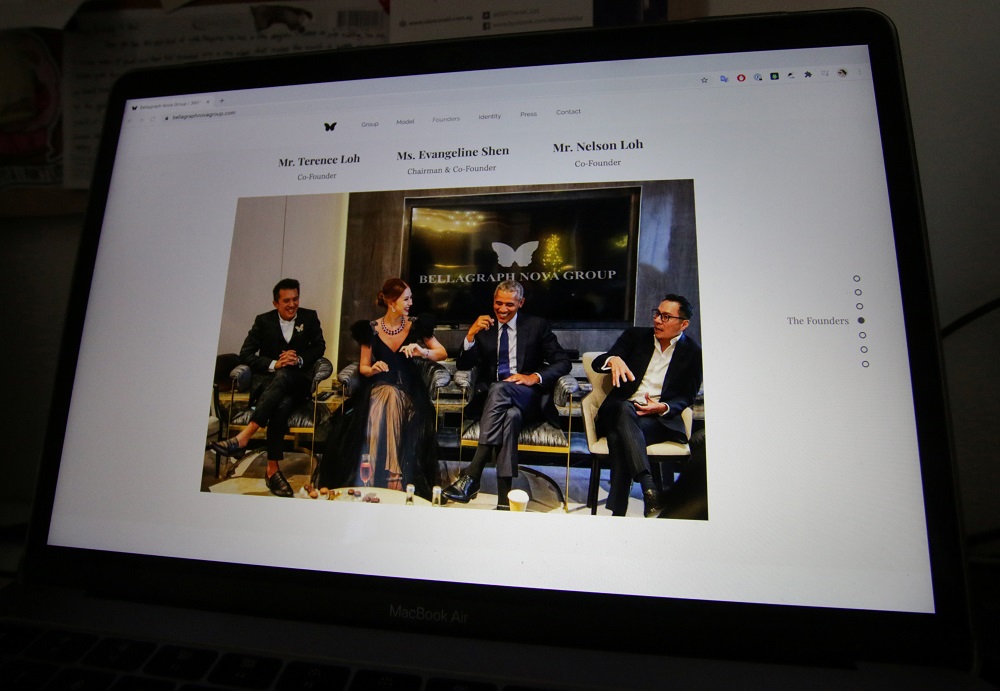 A photo on the website of Bellagraph Nova Group, showing owners Terence (right) and Nelson (left) Loh and Evangeline Shen sitting next to former US President Barack Obama, is pictured on screen, in Singapore August 19, 2020. u00e2u20acu201d Reuters pic