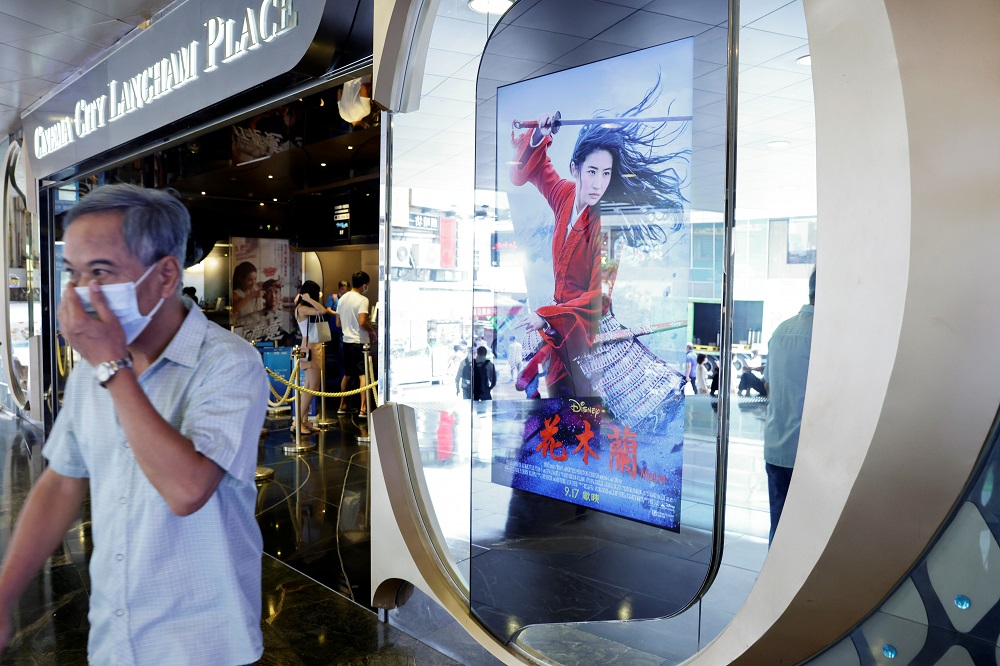 A man wearing a protective mask passes by an advertisement for Walt Disney Cou00e2u20acu2122s live-action war movie u00e2u20acu02dcMulanu00e2u20acu2122 at a cinema in Hong Kong September 16, 2020. u00e2u20acu201d Reuters pic