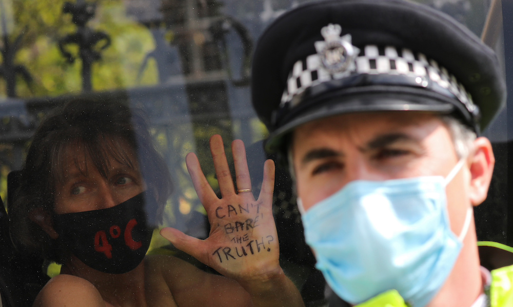 A climate activist shows her hand as she sits inside a police van after being detained during an Extinction Rebellion protest in London, Britain, September 10, 2020. u00e2u20acu201d Reuters pic