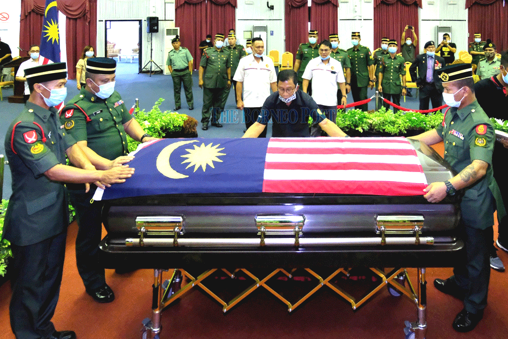 Members of the Malaysian Armed Forces (ATM) place Awang’s casket on a platform before the wake at the Kuching Civic Centre began. — Borneo Post Online pic
