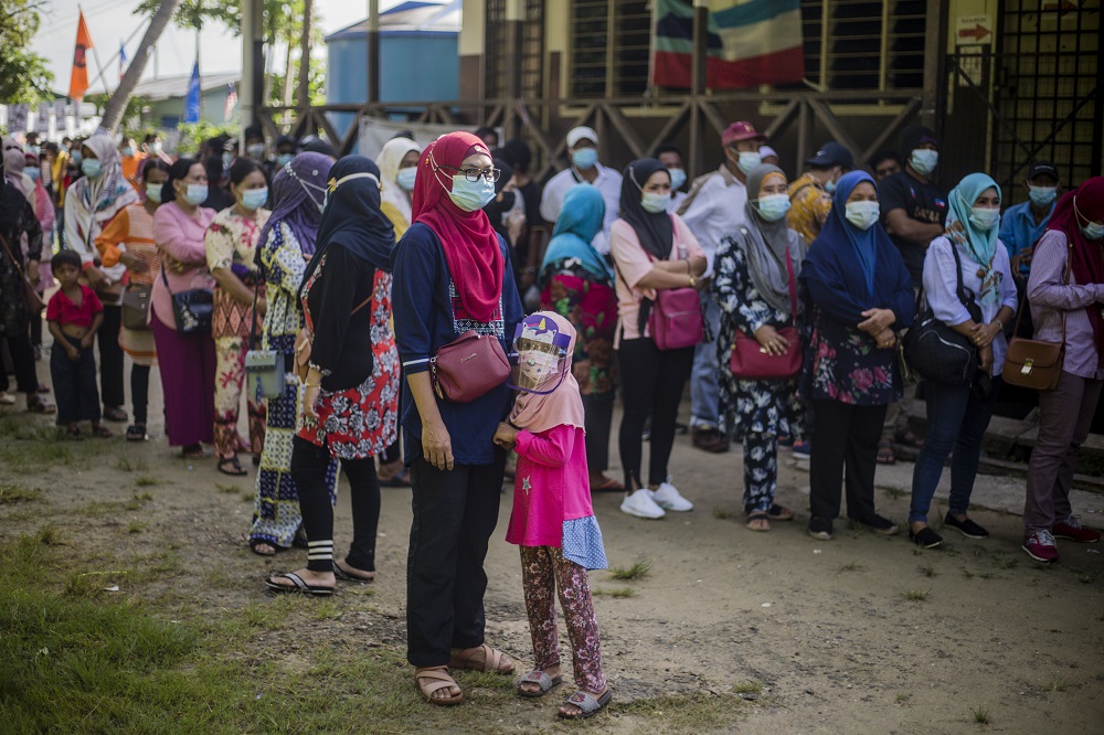 Voters wearing protective masks queue up to cast their votes during the Sabah state election in SK Pulau Gaya September 26, 2020. u00e2u20acu201d Picture by Firdaus Latif