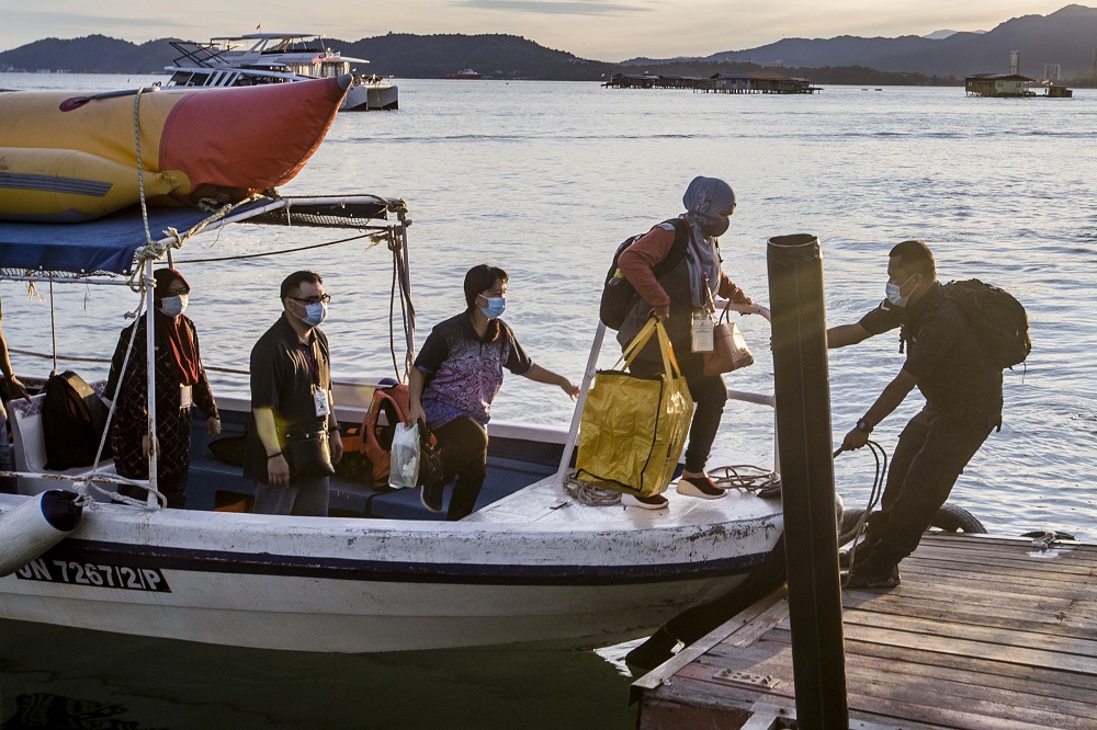 Election Commission personnel arrive at a polling station for the Sabah state election in SK Pulau Gaya September 26, 2020. — Picture by Firdaus Latif