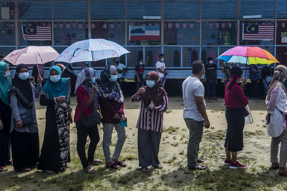 Voters wearing protective masks queue up to cast their votes during the Sabah state election in SK Pulau Gaya September 26, 2020. u00e2u20acu201d Picture by Firdaus Latif