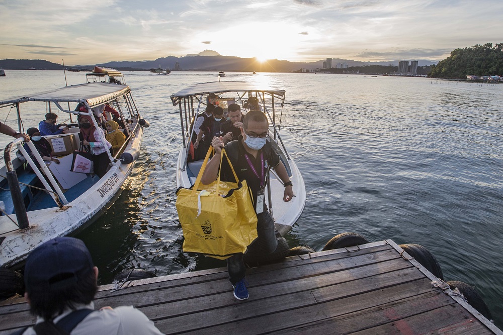 Election Commission personnel arrive at a polling station for the Sabah state election in SK Pulau Gaya September 26, 2020. u00e2u20acu201d Picture by Firdaus Latif