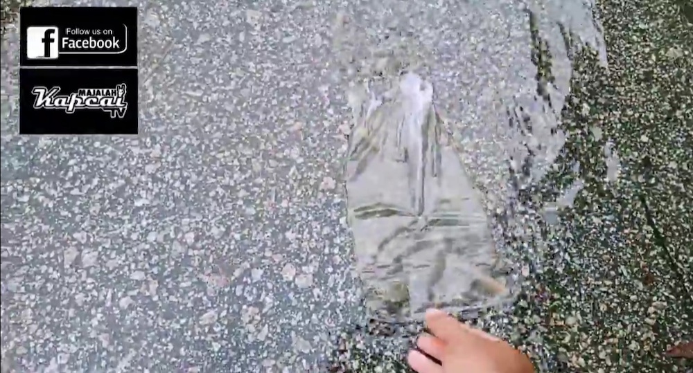 A screengrab of the fishes being released into the flooded motorcycle lane. u00e2u20acu201d Video via Facebook/ Majalah Kapcai TV