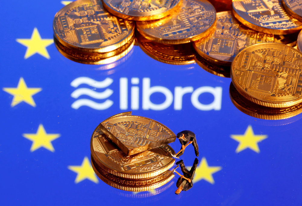 A small toy figure is seen on representations of the virtual currency on a displayed European Union flag and the Facebook Libra logo in this illustration picture, October 20, 2019. u00e2u20acu201d Reuters  pic 