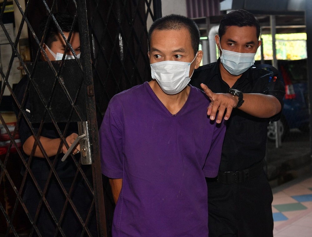 Pang Kar Foong (centre) is led to the Magistrateu00e2u20acu2122s Court in Ipoh September 21, 2020. u00e2u20acu201d Bernama pic