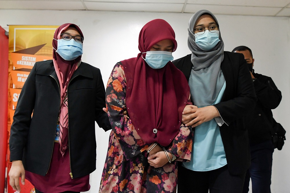 Halimah Musa Brahim (centre) who is now SME Corp economic affairs assistant officer in Kuala Lumpur, is led out of the Sessions Court in Kuala Terengganu September 23, 2020. u00e2u20acu201d Bernama pic