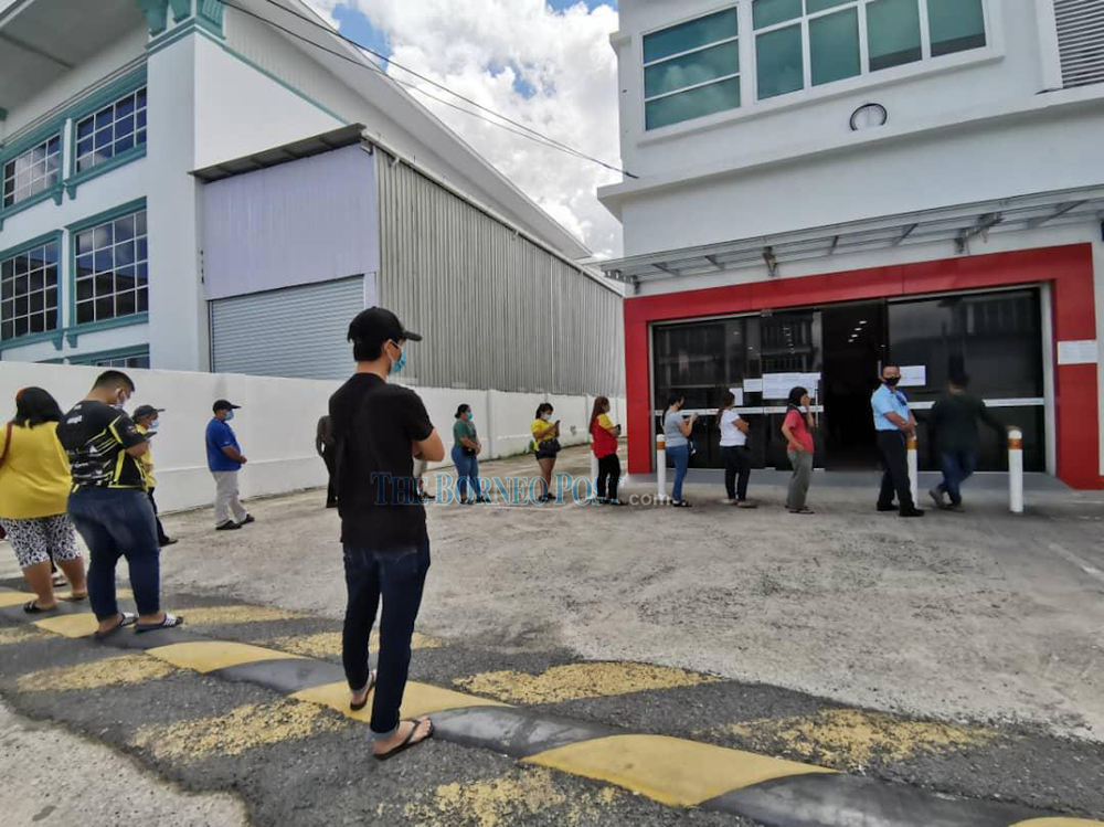 Poslaju customers in East Malaysia waiting to collect their parcels in this file photo. u00e2u20acu201d Borneo Post pic