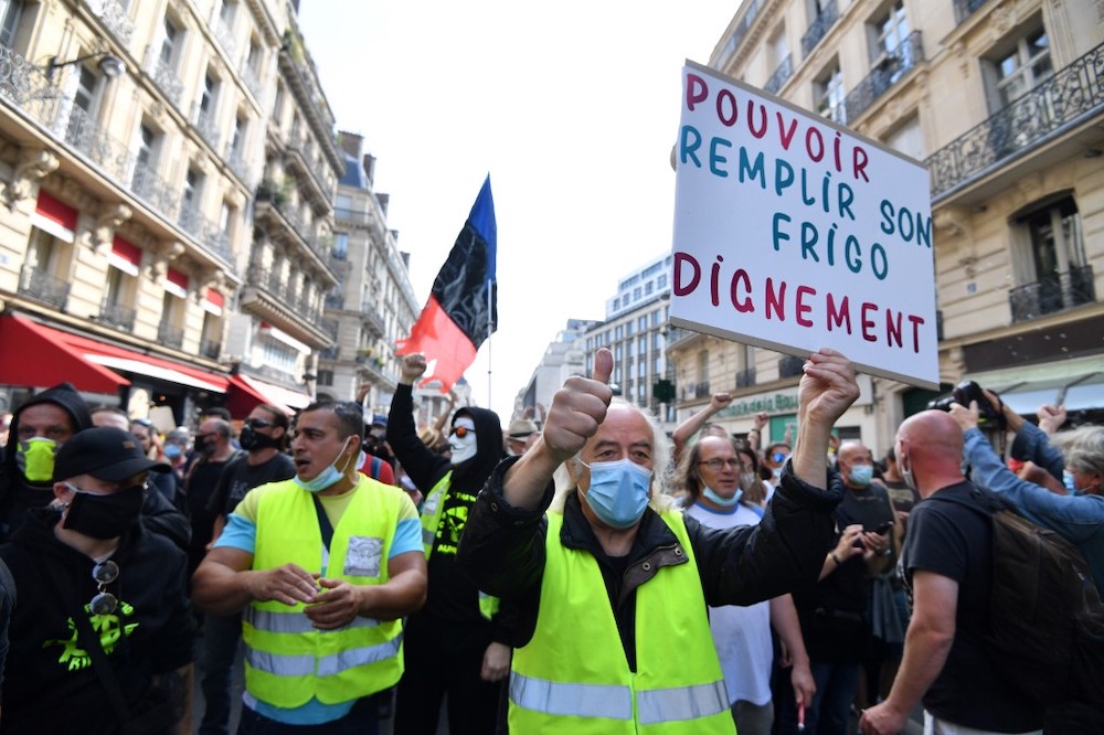 A protester wearing a protective face mask holds a placard reading u00e2u20acu02dcTo be able to fill your fridge with dignityu00e2u20acu2122 during a demonstration called by the u00e2u20acu02dcyellow vestu00e2u20acu2122 (gilets jaunes) movement on September 12, 2020 in Paris. u00e2u20acu201d AFP picnn