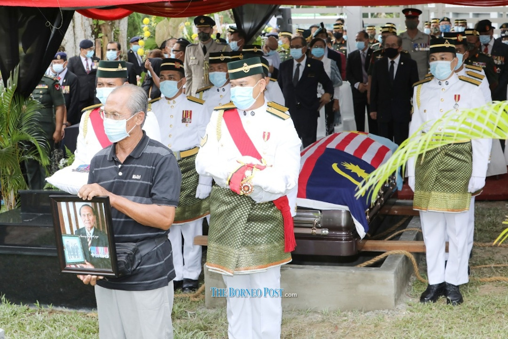 Pall-bearers arriving at the grave site with Datuk Awang Rawengu00e2u20acu2122s eldest son Maling holding his fatheru00e2u20acu2122s portrait. u00e2u20acu201d Borneo Post pic