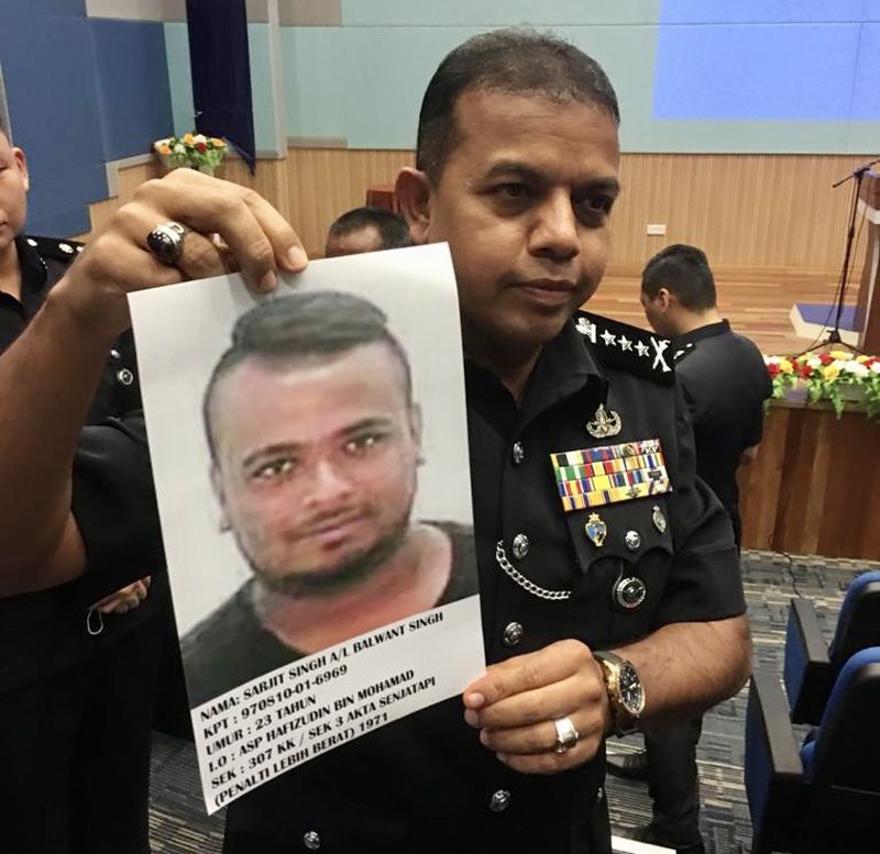 Johor police chief Datuk Ayob Khan Mydin Pitchay with a photofit of the wanted suspect in connection with the case. u00e2u20acu201d Picture by Ben Tan