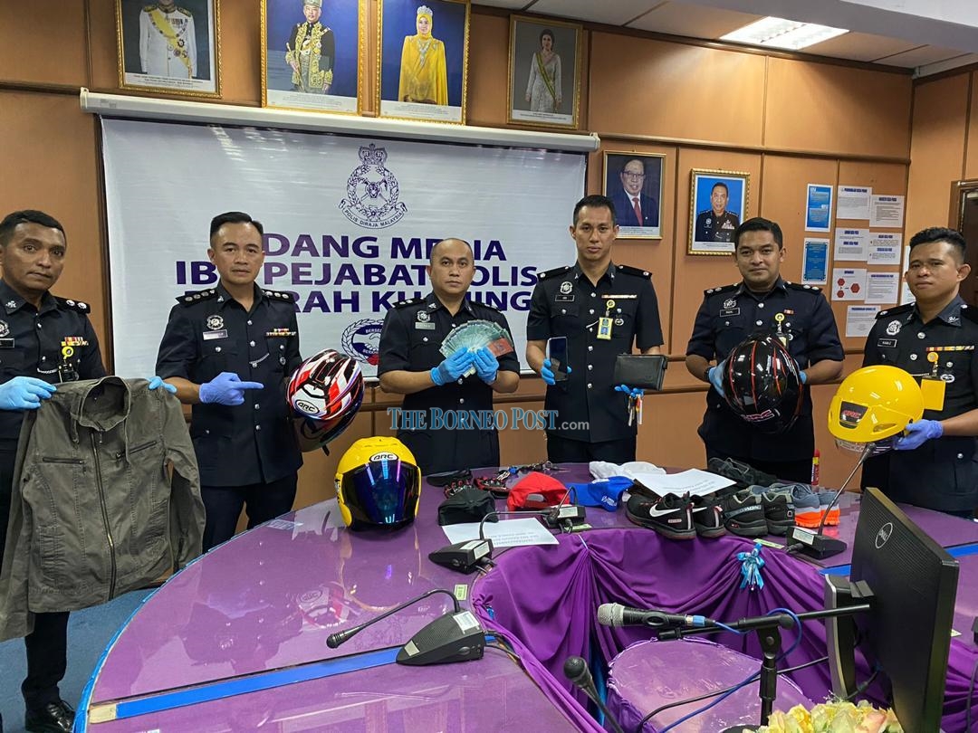 Acting Kuching district police chief Supt Merbin Lisa (centre) and his officers showing some of the items seized from the suspect. u00e2u20acu2022 Borneo Post pic