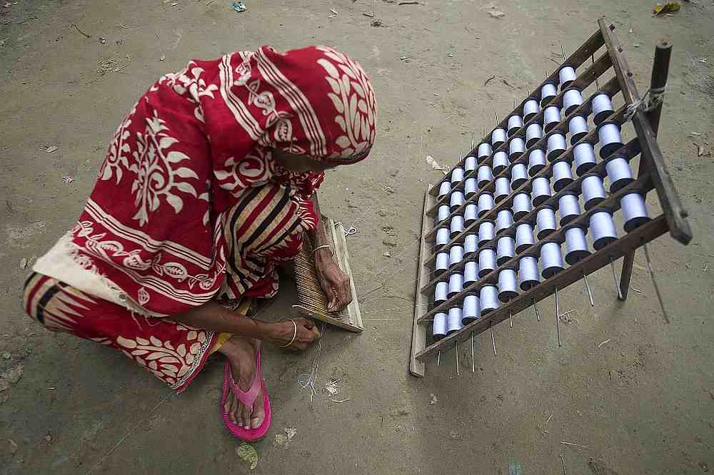 A weaver prepares threads to make fabric with a handloom in Ruhitpur on the outskirts of Dhaka, Bangladesh September 13, 2020. u00e2u20acu201d AFP pic