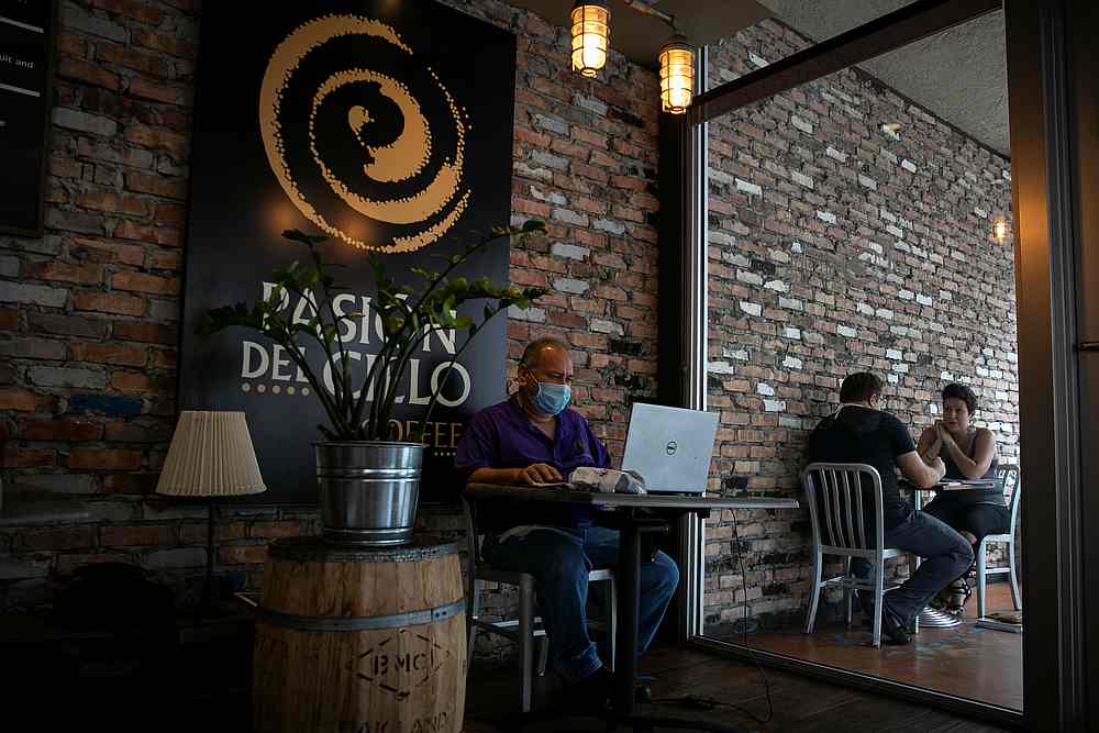 A man works on his laptop inside a coffee shop as Miami-Dade county allows indoor servicing in restaurants after easing some Covid-19 lockdown measures in Miami, Florida August 31, 2020. u00e2u20acu201d Reuters pic