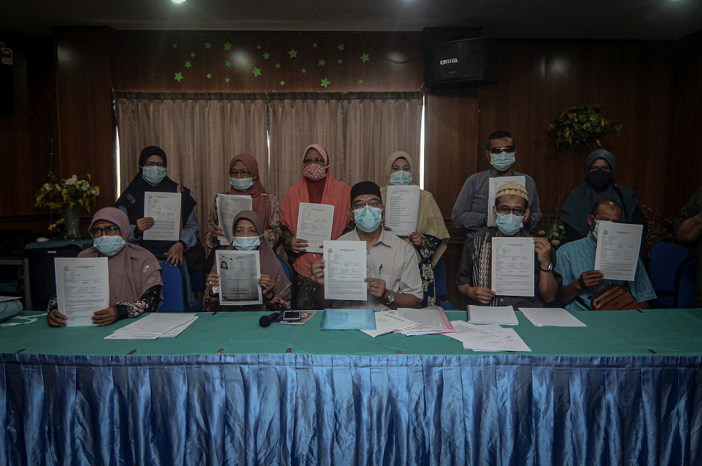Muhammad Radhi Shariff Hussain with 14 other victims of the travel agency showing their police reports in Butterworth, September 8, 2020. u00e2u20acu201d Bernama picn