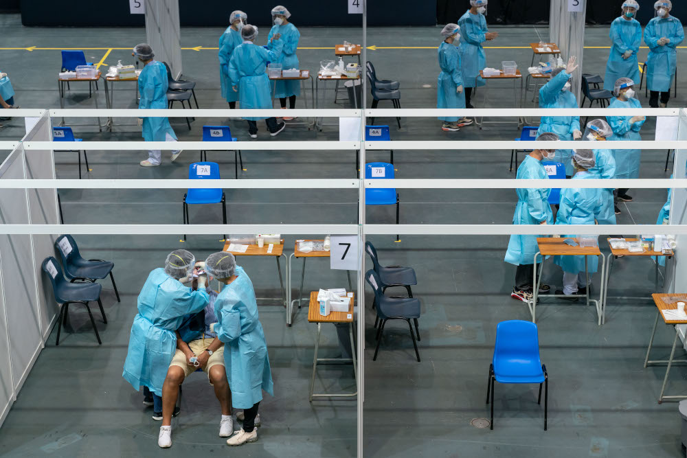 Medical workers collect samples from a man at a makeshift testing site for Covid-19 infections at the Queen Elizabeth Stadium in Hong Kong September 1, 2020. u00e2u20acu201d AFP pic 