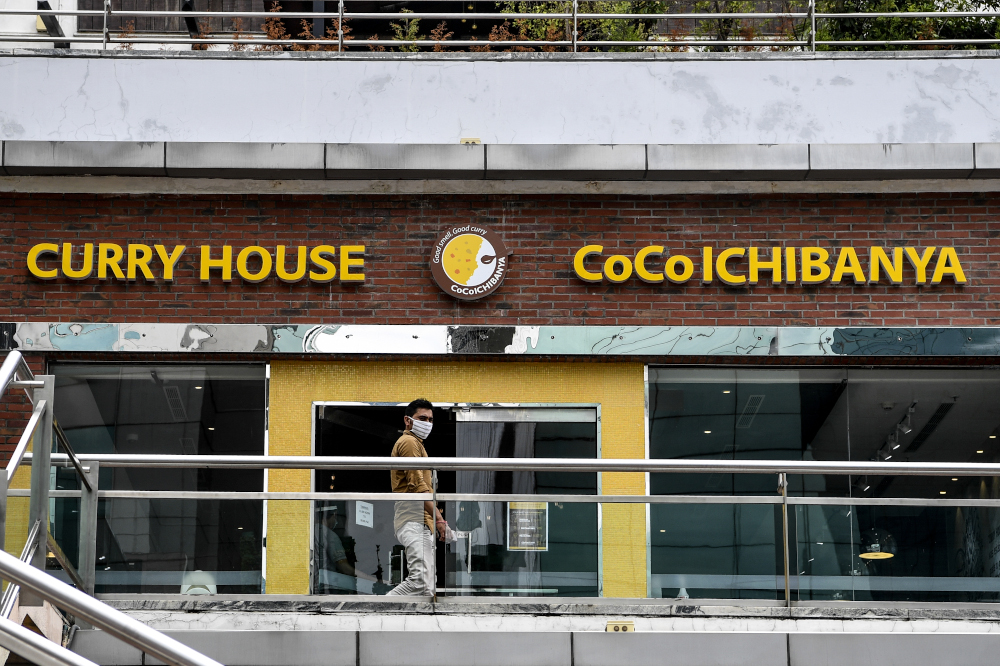 In this picture taken August 26, 2020, a man walks in front of the entrance of an outlet of CoCo Ichibanya Japanese curry chain restaurant in Gurgaon on the outskirts of New Delhi. u00e2u20acu201d AFP pic