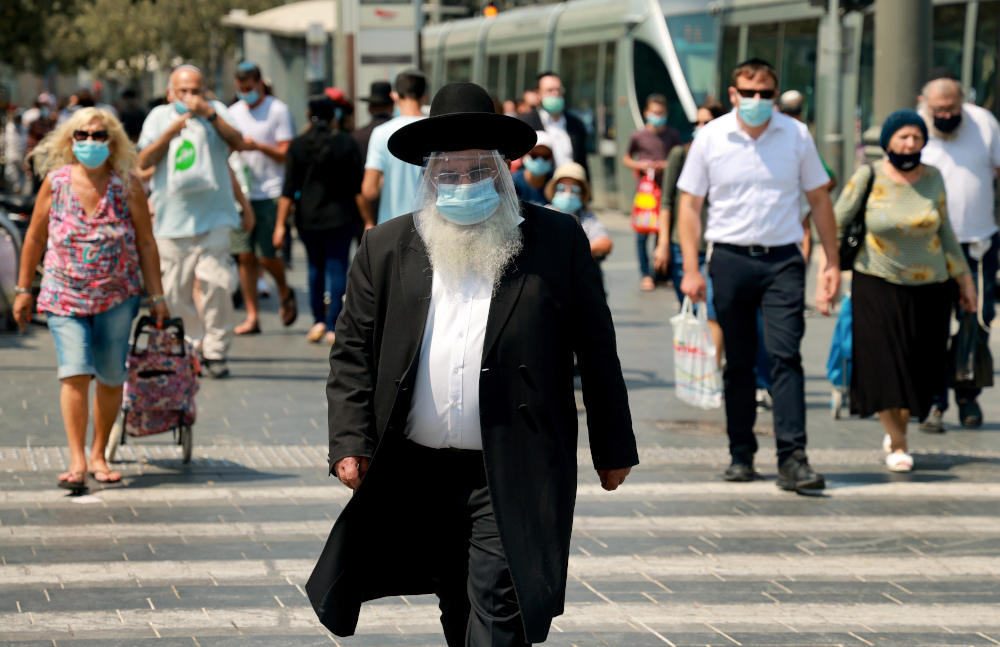 An ultra-Orthodox Jewish man wearing a protective mask and shield against the coronavirus, walks along a street in Jerusalem September 11, 2020. u00e2u20acu201d AFP pic 