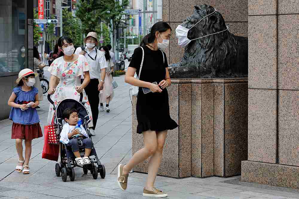 Pedestrians wearing protective masks walk past a statue with a mask on in front of a department store, amid the Covid-19 pandemic in Tokyo, Japan August 18, 2020. u00e2u20acu201d Reuters pic