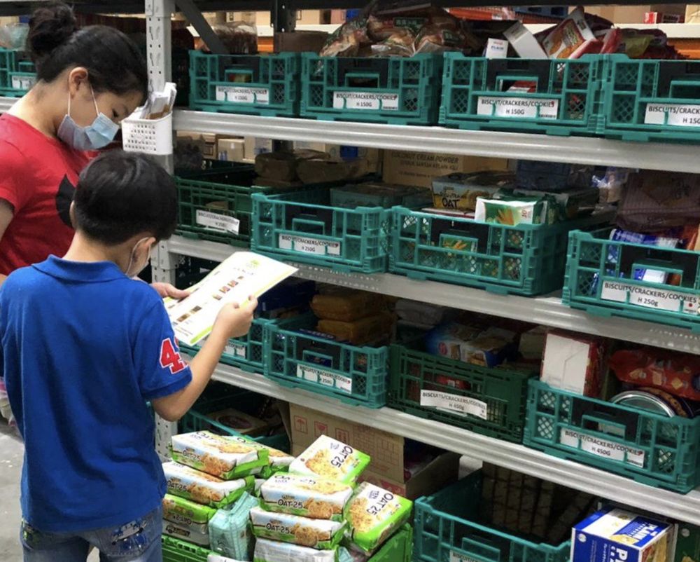 Volunteers pitching in to support The Food Bank Singapore, with some turning up with their children to help pack food items for the needy. — The Food Bank Singapore/Facebook/TODAY pic