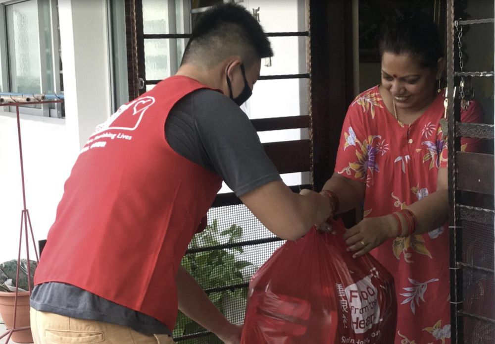A volunteer with Food from the Heart delivering a food pack to a beneficiary. — Food from the Heart/TODAY pic