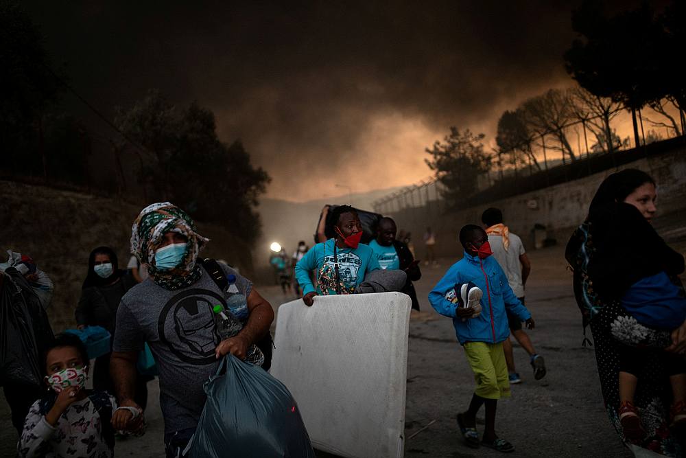 Refugees and migrants carrying their belongings flee a fire burning at the Moria camp on the island of Lesbos, Greece September 9, 2020. u00e2u20acu201d Reuters pic