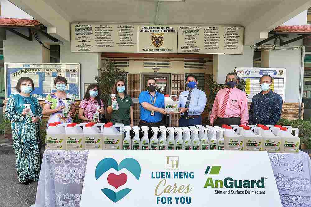Methodist Boys’ School principal Brendan Ravi Chandran (third from right) receives the disinfectant from Luen Heng F&B commercial director Sean Soh at a handover ceremony. — Picture by Ahmad Zamzahuri