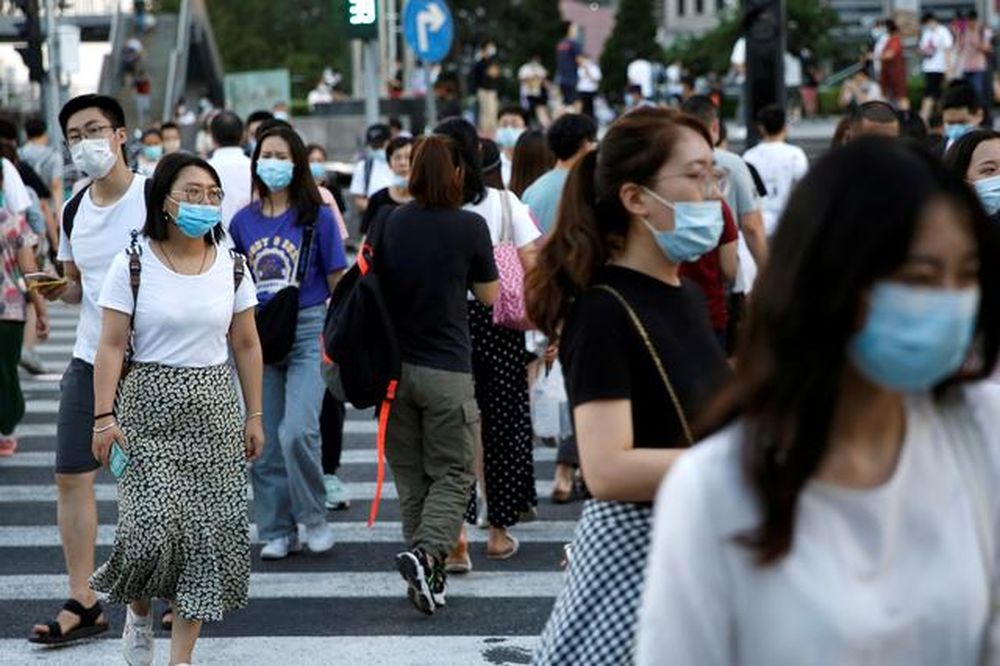 People wearing face masks following the coronavirus disease (Covid-19) outbreak walk across a street at a shopping area in Beijing, China August 25, 2020. u00e2u20acu201d Reuters pic
