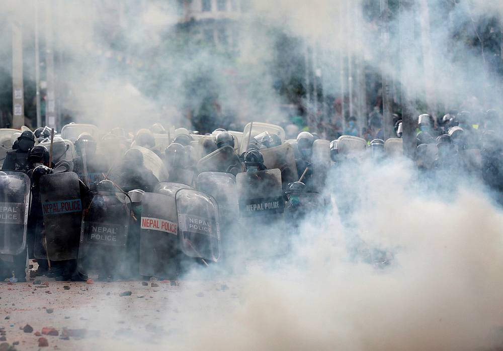 Nepalese police take cover during a protest after locals tried to pull the chariot of Rato Machhindranath in Lalitpur, Nepal September 3, 2020. u00e2u20acu201d Reuters pic