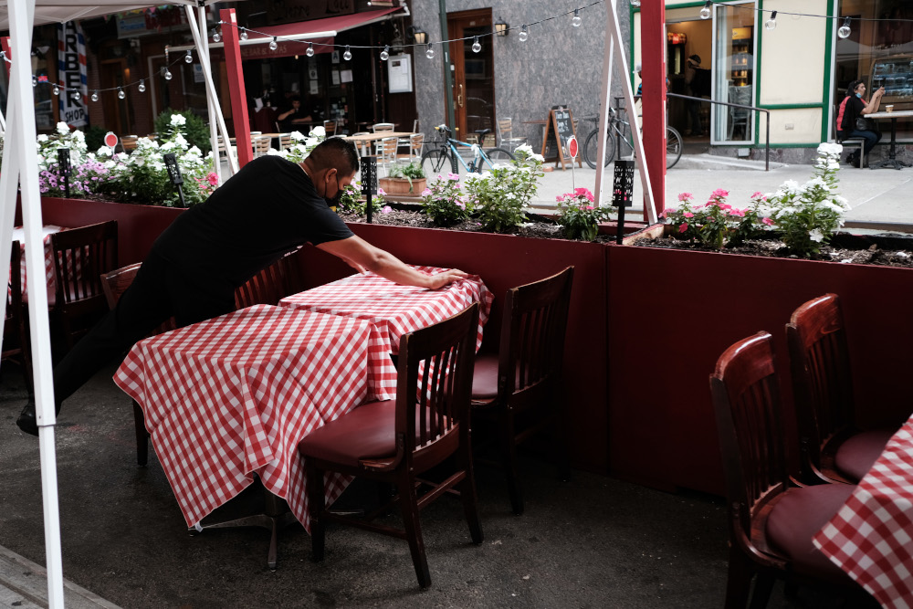 In this file photo taken August 30, 2020 a member of the staff prepares a table at a restaurant in Manhattan in New York City. u00e2u20acu201d Spencer Platt/Getty Images pic via AFP 
