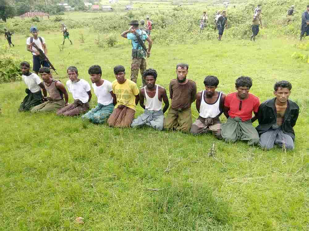 Ten Rohingya men with their hands bound kneel as members of the Myanmar security forces stand guard in Inn Din village of Rakhine State, Myanmar September 2, 2017. u00e2u20acu201d Handout via Reuters