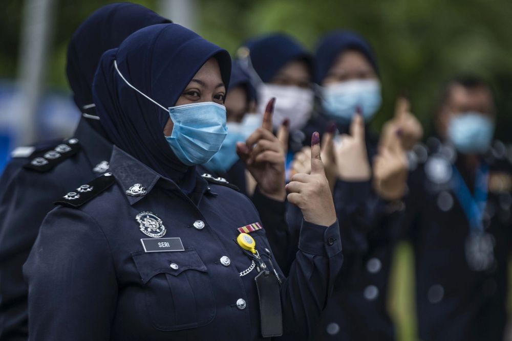 Police officers show their ink-stained fingers after casting their ballots during early voting for the Sabah state poll in Kota Kinabalu September 22, 2020. u00e2u20acu201d Picture by Firdaus Latif