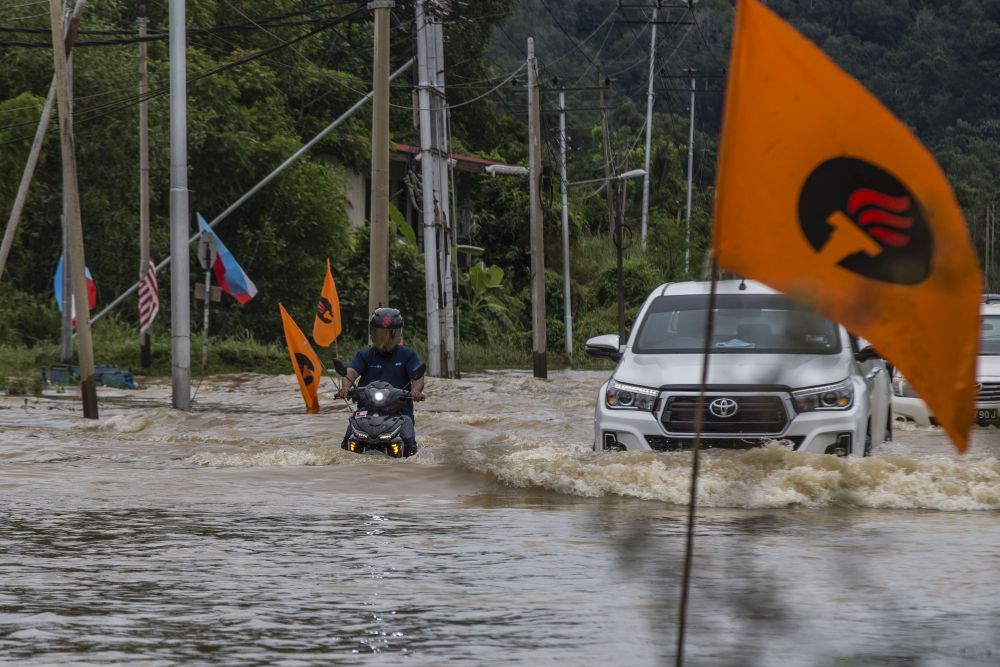 Motorists brave the flood waters on Jalan Datuk Panglima Banting in Penampang, Sabah September 15, 2020. — Picture by Firdaus Latif