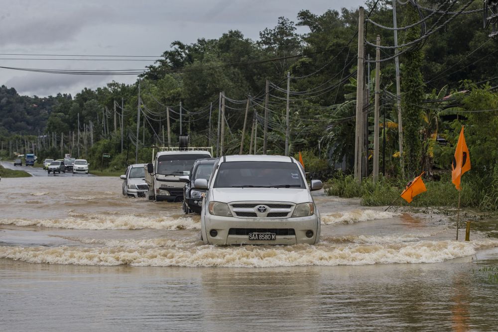 Motorists attempt to drive through flood waters on Jalan Datuk Panglima Banting in Penampang, Sabah September 15, 2020. u00e2u20acu201d Picture by Firdaus Latif