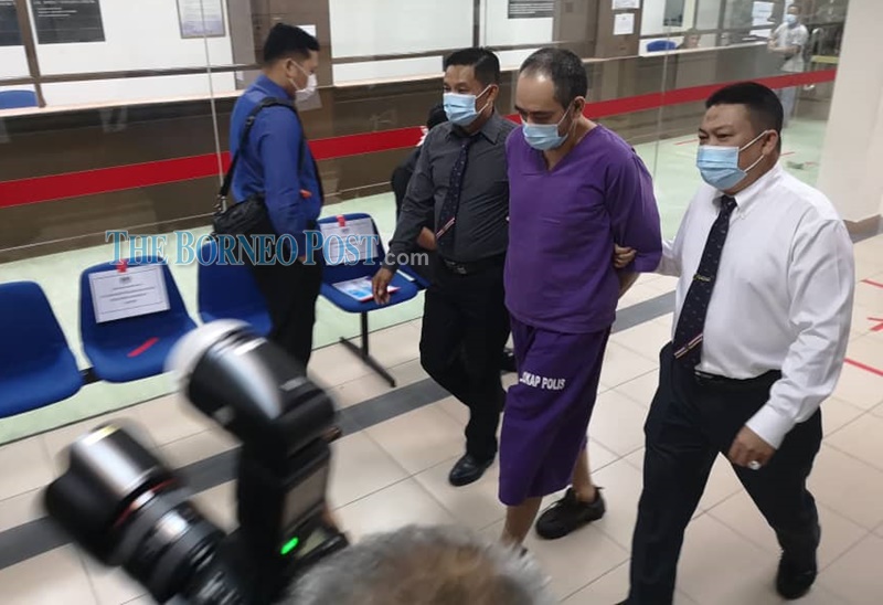 The accused Shaifullizan Abdul Mutali being escorted to court on August 14 for a remand order. u00e2u20acu201c Borneo Post pic