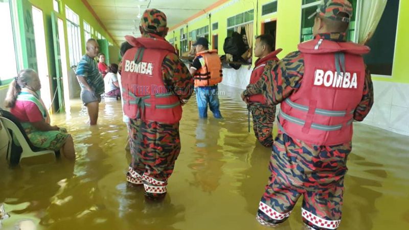 Firemen assisting residents of the inundated Rh Kulleh in Song to evacuate. u00e2u20acu201d Borneo Post pic