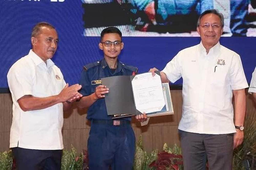 Shazrin Hafeez (centre) receiving the certificate of appreciation from Johor Menteri Besar Datuk Hasni Mohammad (right). u00e2u20acu201d Picture via Facebook/InfoRoadblockJPJ/POLIS