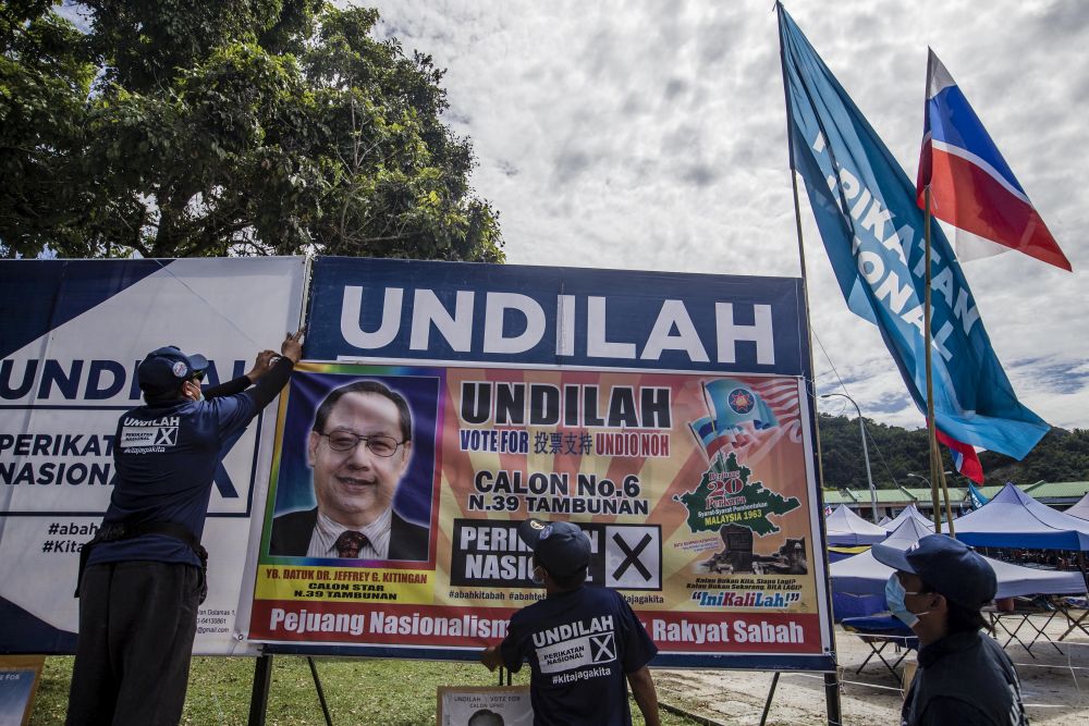 Workers are pictured putting up a poster of STAR president Datuk Jeffrey Kitingan in Tambunan September 24, 2020. u00e2u20acu201d Picture by Firdaus Latif