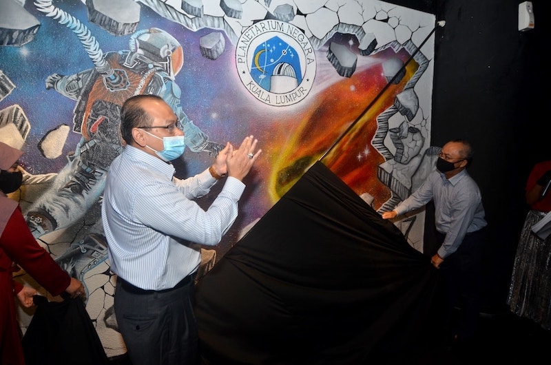 Deputy Minister of Science, Technology and Innovation Ahmad Amzad Hashim unveiling a space-themed mural during the launch ceremony. u00e2u20acu201d Picture via Facebook/Kementerian Sains, Teknologi dan Inovasi (Mosti)