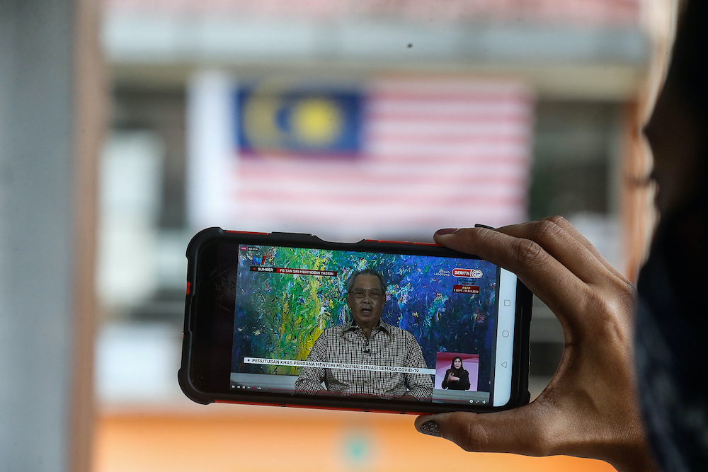 A smartphone screen shows  Prime Minister Tan Sri Muhyiddin Yassin giving his special announcement, October 6, 2020. u00e2u20acu201d Picture by Sayuti Zainudin