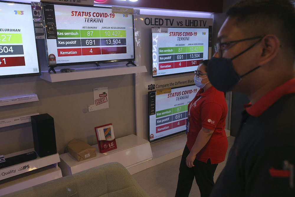 Television screens show Director General of Health Malaysia Tan Sri Dr Noor Hisham Abdullah holding a press conference from his home during his quarantine, October 6, 2020. — Picture by Hari Anggara