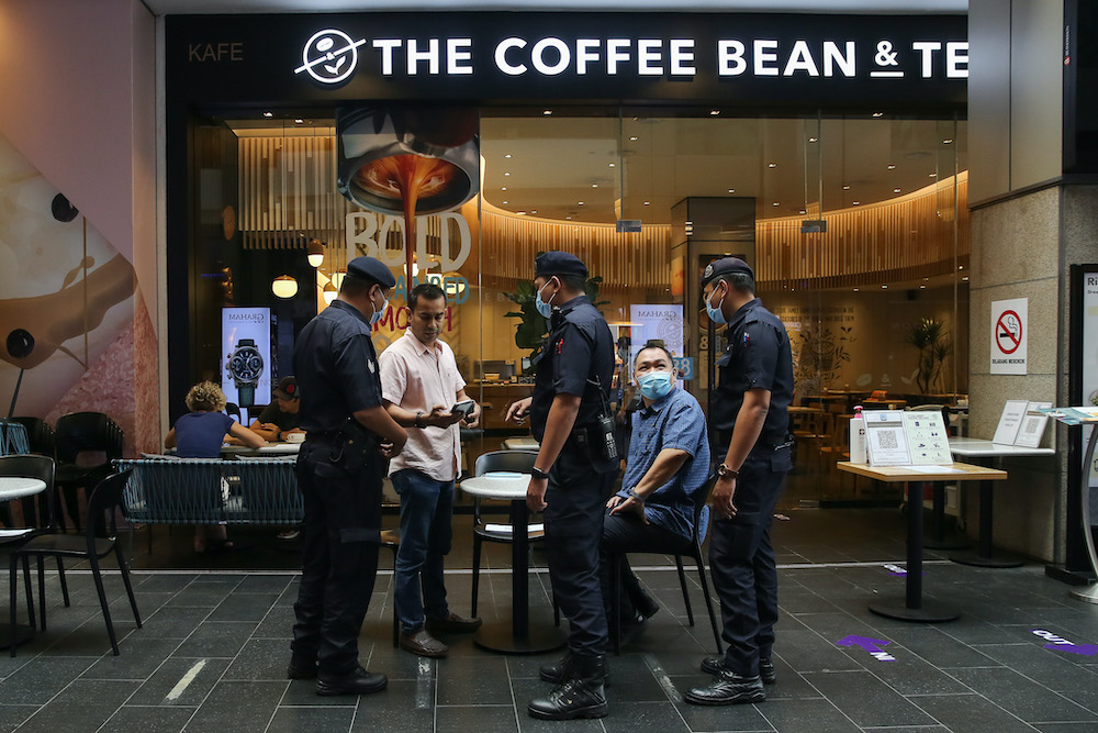 Police officers monitor the standard operating procedures compliance during the conditional movement control order at Pavilion Kuala Lumpur. u00e2u20acu201d Picture by Yusof Mat Isa