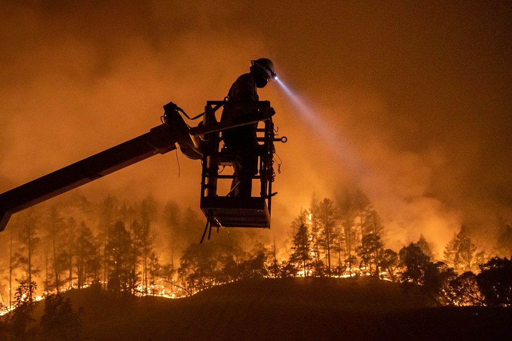The Glass Fire burns in the background as Josh Asbury, an employee of CableCom, installs fibre optic cable in Calistoga, California September 28, 2020. u00e2u20acu201d Reuters pic