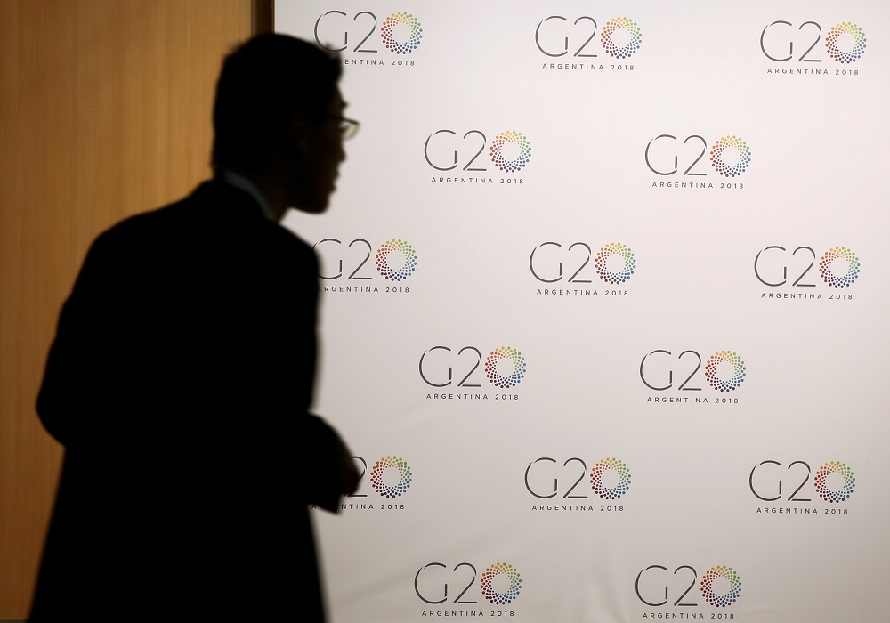 A man stands next to a board with the G20 Meeting of Finance Ministers logo in Buenos AiresMarch 19, 2018. u00e2u20acu201d Reuters pic